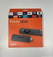 Front of the unopened Amazon Fire TV Stick box showing device and remote image and supported streaming services logos.