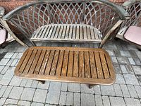Close up view of double-seat wooden bench and rectangular wooden coffee table showing weathered wood condition with iron frame.
