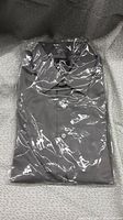 Dark gray dress shirt folded and sealed in clear plastic wrapping