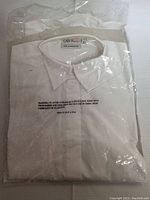 White Chef Works server shirt sealed in plastic packaging, size label visible.