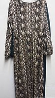 Single snake print green dress hung on wall