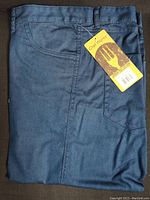 Folded indigo blue Chef Works pants with tag showing the brand and series 'Urban Collection'