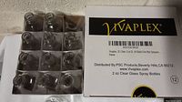 Top view of multiple clear glass 2oz bottles arranged in trays inside a Vivaplex labeled box.