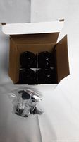 Top view of open box revealing 4 amber glass bottles inside and a small bag of black lotion pumps.