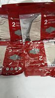 Sealed red and clear plastic Swiss Mobility packs, each containing two beige face masks.