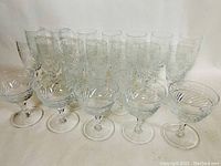Front view of entire set of crystal stemware arranged in rows showing variety of sizes and matching patterns.