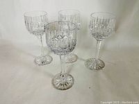 Four clear Atlantic crystal stemware glasses arranged for visibility of their cut patterns and stems.