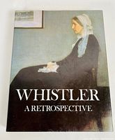 Front cover of the hardcover book featuring a painting of a seated woman in period attire with the title 'Whistler A Retrospective'.