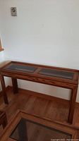 Full front view of the oak side table showing wood grain and glass inserts on top.