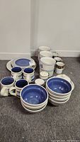 Full view of the Pfaltzgraff stoneware collection including bowls, plates, mugs, salt and pepper shakers, butter tubs, and covered dish