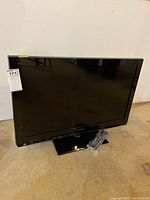 Front view of the Panasonic flatscreen TV, showing the screen and base stand with remote in front.