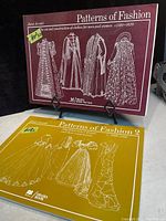 Front covers of both paperback volumes displayed upright—maroon volume for 1560-1620 and mustard yellow for 1860-1940.