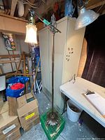 Full view of the antique bridge floor lamp showing height, base, and arm in setting with other items.
