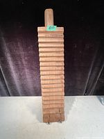 Full frontal photo of antique wooden mangle with visible ridged surface and handle