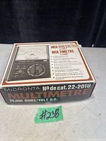 Closed box of Micronta multimeter model 22-201U showing front with product image and key specifications including 20,000 OHMS/VOLT D.C.