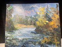 Clear image of the vintage oil on board painting showing a natural landscape with a river and trees in autumnal colors under a partly cloudy sky.