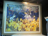 Full view of the framed painting showing vibrant iris flowers in yellows and dark blues, with visible textured brushstrokes.