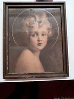Front view of antique framed portrait of a young girl with curly hair and halo ring detail, wood frame showing minor wear.