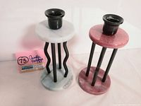 Photo showing both unique candle holders side by side with a pink auction tag.