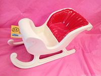 Left side view of 14-inch ceramic Christmas sleigh showing white body with red seat and curved runners