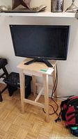 Full view of Acer 23 inch monitor on wooden stool, showing front and stand.