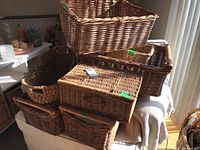 Seven wicker baskets stacked and arranged, showing variety in size and shape.