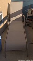 Straight view of the lounger chair showing the flat seating area and frame in natural light.