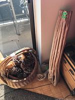Wicker basket filled with pine cones and decorative wood stumps arranged vertically beside it.