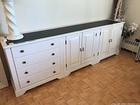 Full front view of sideboard showing drawer section at left and two cabinet sections at right under black slate top