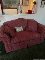 Front view of BF Bryant loveseat showing red floral patterned upholstery and pillows on carpet.