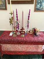 Table display of candle holders with spiral candles, faux floral bouquet, and decorative table runner