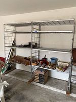 Front view of double and single metal shelving units with various small items on shelves.