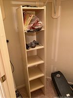 Front view of laminate shelf showing five shelves with vacuum cleaner attachments stored inside (not included).