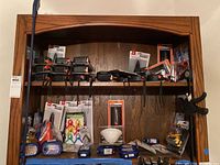 Wooden shelves fully stocked with various hand tools, clamps, tape measures, scissors, and levels packed and unpacked.