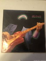 Front cover of LP with stylized guitar player artwork and album title 'Dire Straits Money for Nothing'