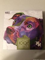 Top side of sealed puzzle box with colorful abstract dog image and 1000 piece label