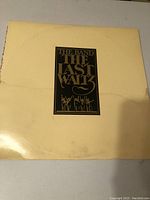 Front cover of The Last Waltz album showing cream color with black and gold title graphic. Cover has visible water damage.