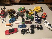 Full view of all toys arranged on a table showing variety of toy vehicles including helicopters, cars, and construction vehicles.