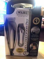 Front of boxed WAHL Deluxe Groom Pro showing electric clipper and trimmer images and key features.
