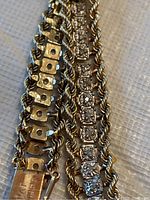 Close-up of twisted rope chain alongside stone set square bezel links