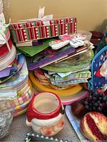 Close-up of ceramic Santa-shaped mug and pile of assorted linens and gift wrap