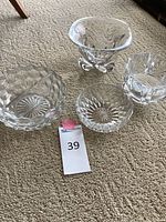 Four different crystal candy dishes displayed on carpet, showing variety of shapes and patterns