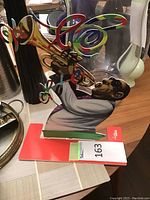 Front view of the colorful metal jazz trumpeter bookend with vivid swirling colors coming out from the trumpet held by a jazz musician figure.