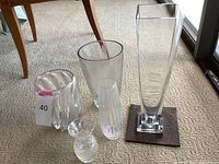 All four vases arranged on carpet, showing size and shapes including tall rectangular, large rounded with ridges, smaller ridged, and small patterned.