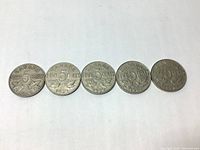 Five Canadian 5 cent coins laid out in a row showing reverse sides with dates 1929, 1930, 1932, 1936 and one additional coin.