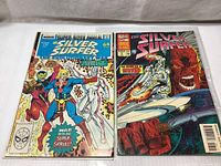 Front covers of Silver Surfer Annual #1 (1987) and Annual #7 (1994) comic books showing characters and title details.