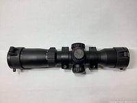 Front angle view of Excalibur Tact 100 crossbow scope showing overall body, included rings, dial and flip-up lens caps