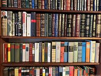Two full bookshelves filled with assorted vintage books of various genres and sizes.