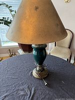 Full view of the lamp with shade on a table, showing overall condition and size.
