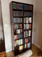 Front view of two matching mahogany-finish bookshelves filled with books